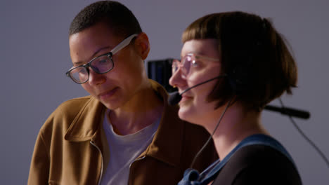 Female-Film-Director-And-Assistant-Shooting-Movie-Or-Video-Discussing-Scene-In-Studio-Shot-In-Real-Time